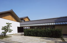 店舗外観。屋根は鉄骨の小屋組を主とし、それに奈良の吉野杉の集成材を組み合わせた構造
