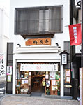 神楽坂「梅花亭」外観。４階建ての自社ビル。１階は店舗（５坪）と工場（10坪）。２～４階は包装室、倉庫、更衣室、休憩室、事務所等となっている